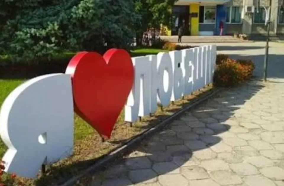 Білі об’ємні літери «Я люблю Любешів» із червоним серцем біля тротуару