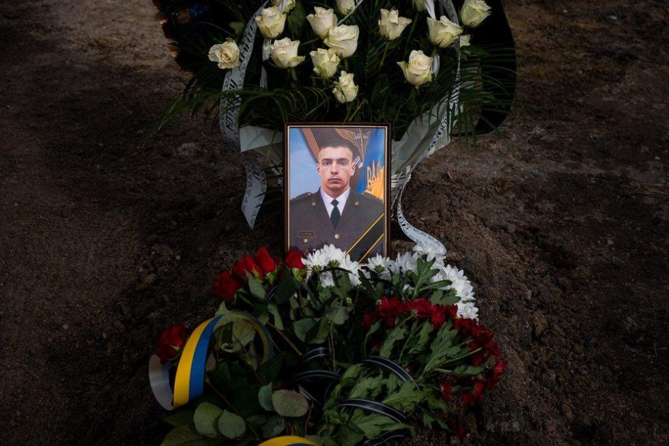 Портрет воїна на меморіальному могильнику з квітами