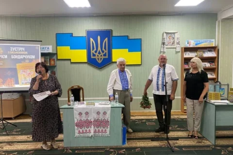 Презентація книги в бібліотеці: екран, тризуб, прапор і люди у вишиванках