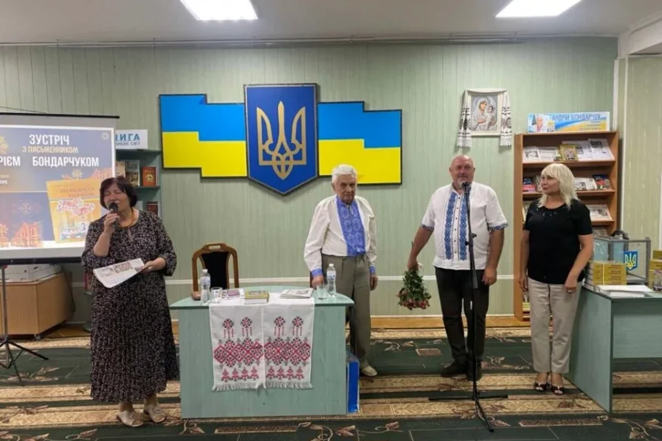 Презентація книги в бібліотеці: екран, тризуб, прапор і люди у вишиванках